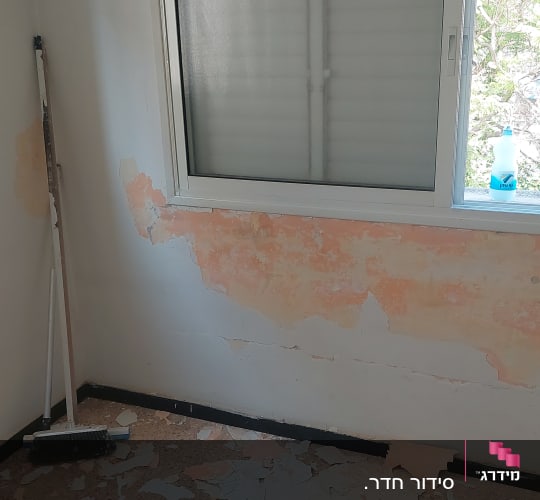 קיר מתקלף עם צבע מתקלף על הרצפה